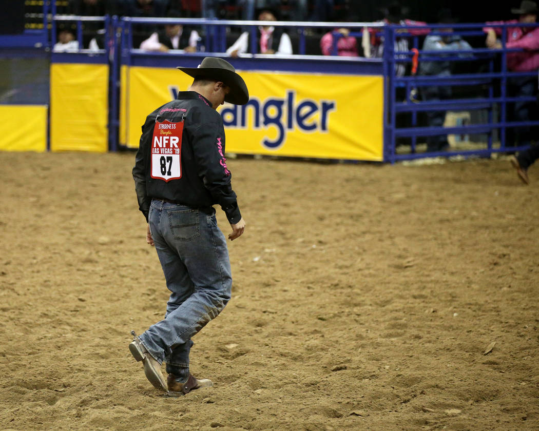 J.D. Struxness of Milan, Minn. walks off the dirt after failing to catch his steer in the Steer ...