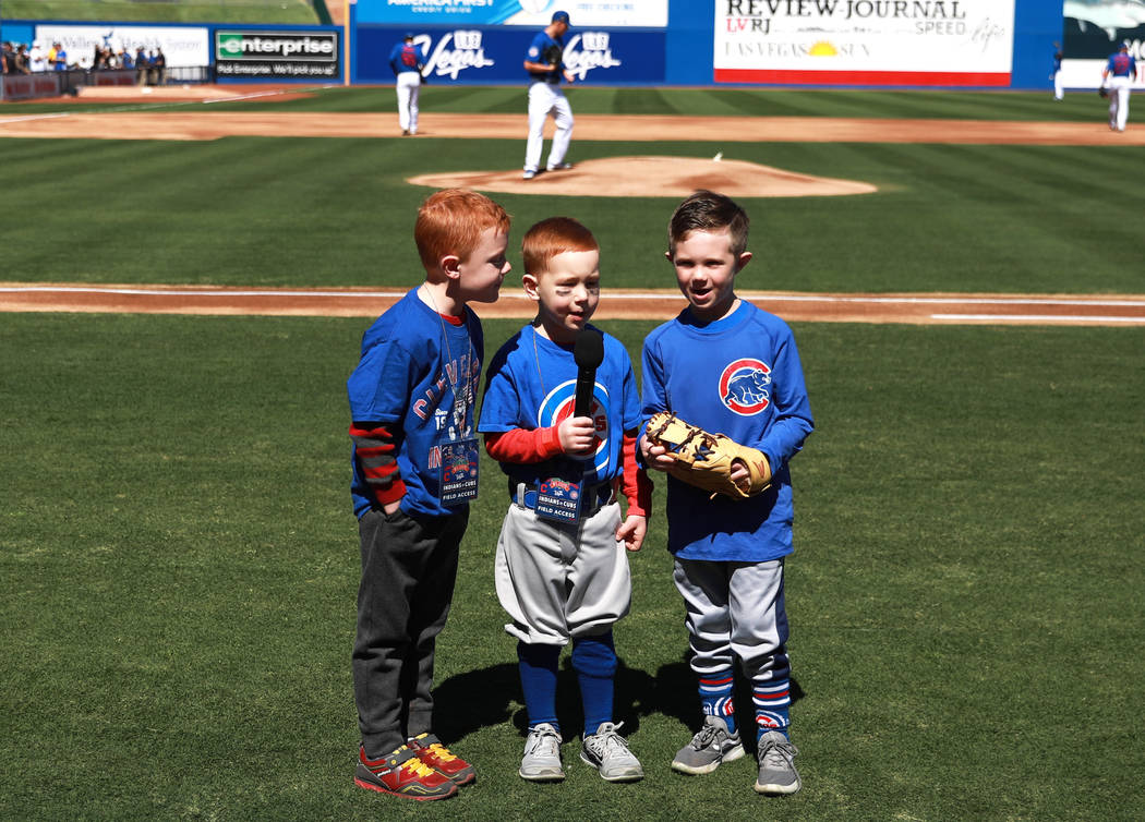 Three young boys announce the start of the annual Big League Weekend baseball game at Cashman F ...