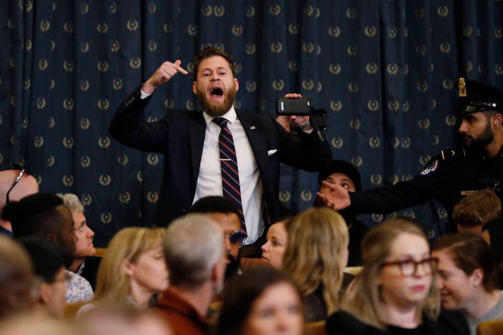 A protestor speaks out as the House Judiciary Committee hears investigative findings in the imp ...