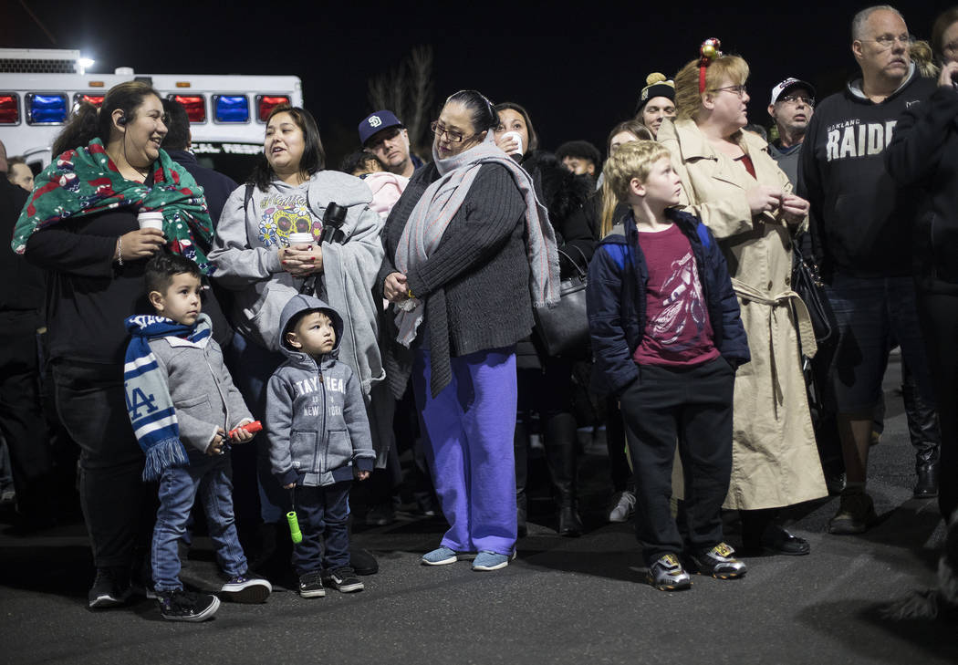 A crowd waits in the parking lot to shine flashlights at children who are stuck in the hospital ...