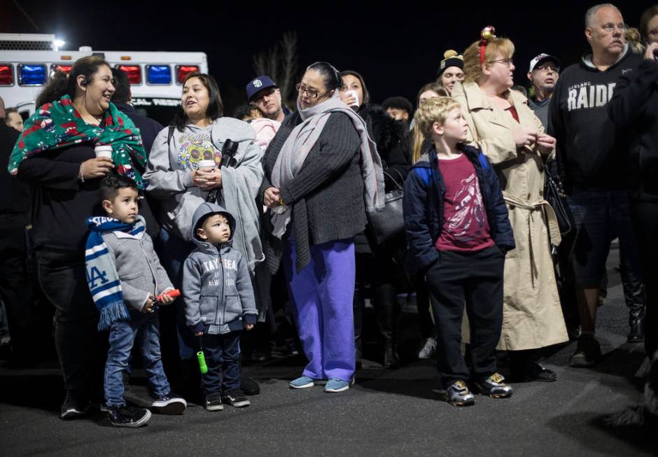 A crowd waits in the parking lot to shine flashlights at children who are stuck in the hospital ...