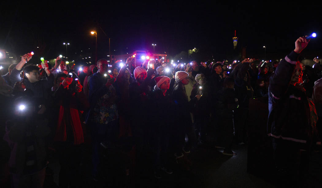 A group of community members and first responders shine lights into the third floor of UMC Chil ...