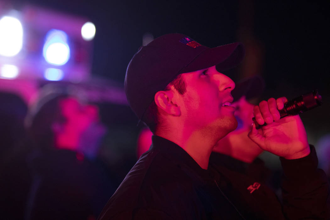 MedicWest EMT Victor Hurtado shines a flashlight up to kids who will be spending the holidays i ...