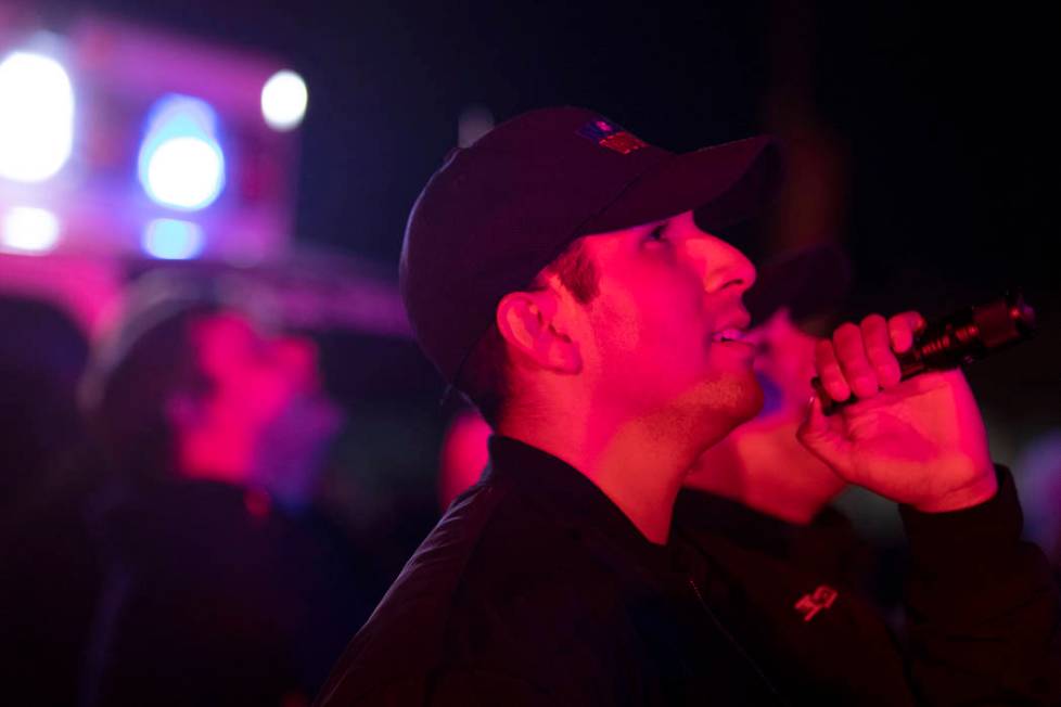 MedicWest EMT Victor Hurtado shines a flashlight up to kids who will be spending the holidays i ...