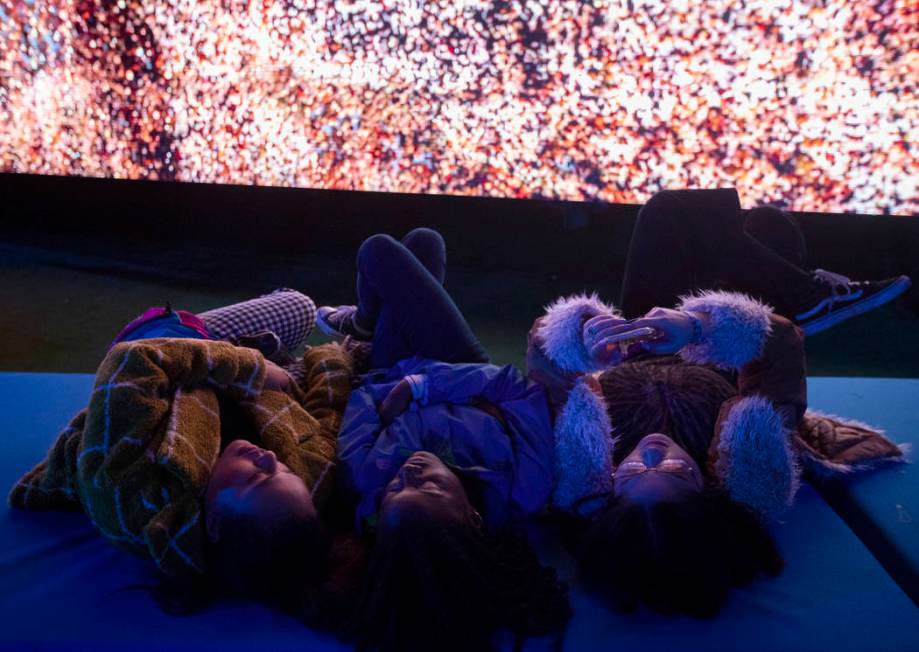 Tanisha Tavares, left, Raina Brown, center, and Jennifer Paloma, right, take a rest while watch ...