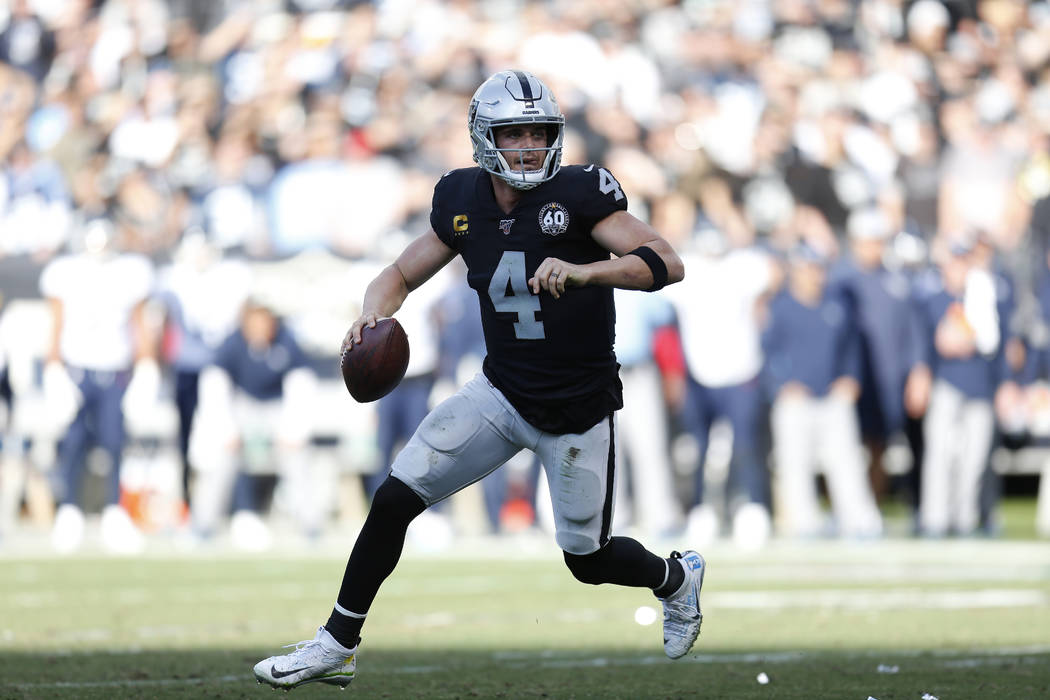 Oakland Raiders quarterback Derek Carr (4) rolls out to pass against the Tennessee Titans durin ...