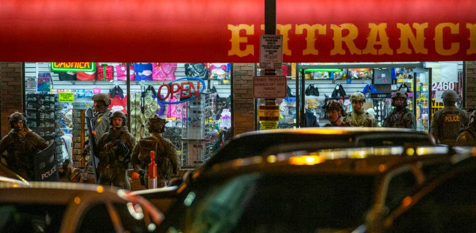 Las Vegas police gather at the store entrance as they work a barricade situation of a woman wit ...