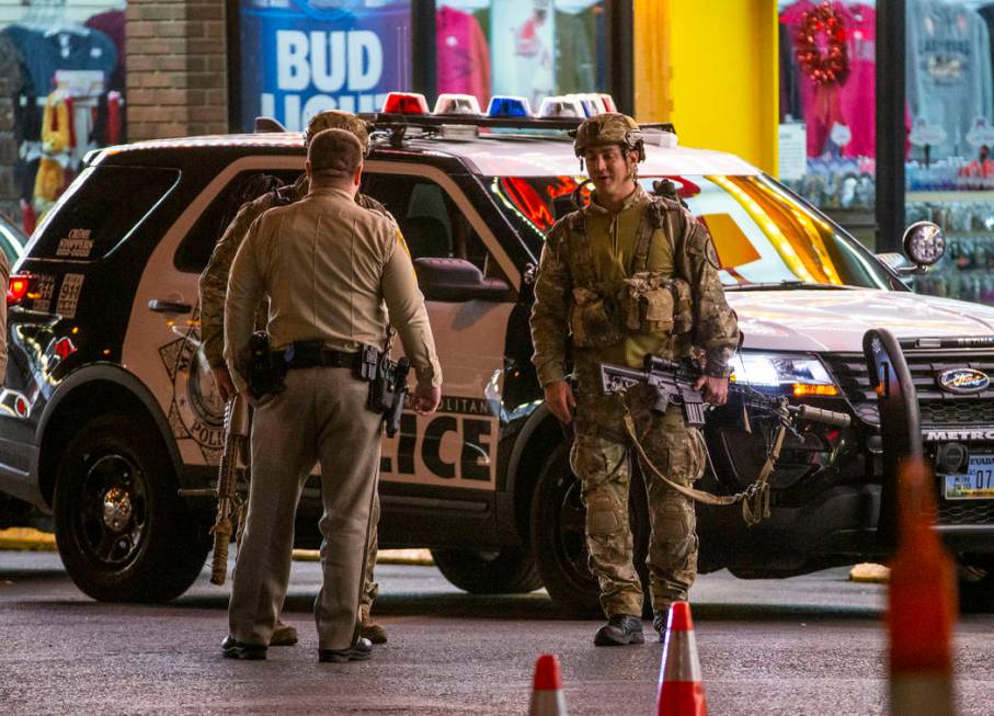 Las Vegas police gather in the parking lot as they work a barricade situation of a woman with a ...