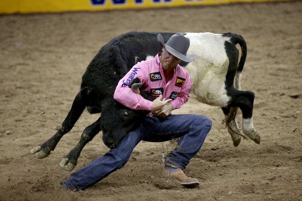 Cameron Morman of Glen Ullin, N.D. competes in Steer Wrestling during Bareback Riding in the fi ...