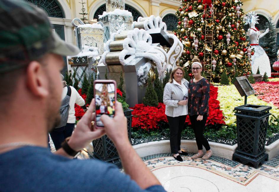 Rick Musser takes a photo of Carol Vallozzi, left, and his wife Hannah Musser at the Bellagio C ...