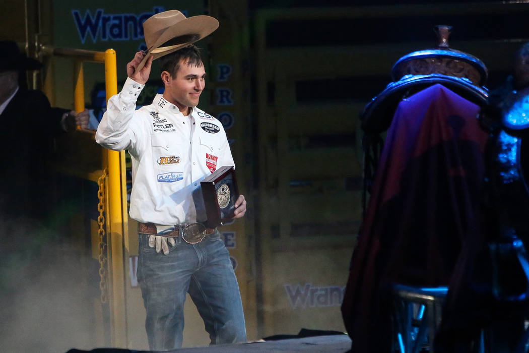 Clay Smith of Broken Bow, Okla. (22) walks up to be honored on stage after winning the Team Rop ...