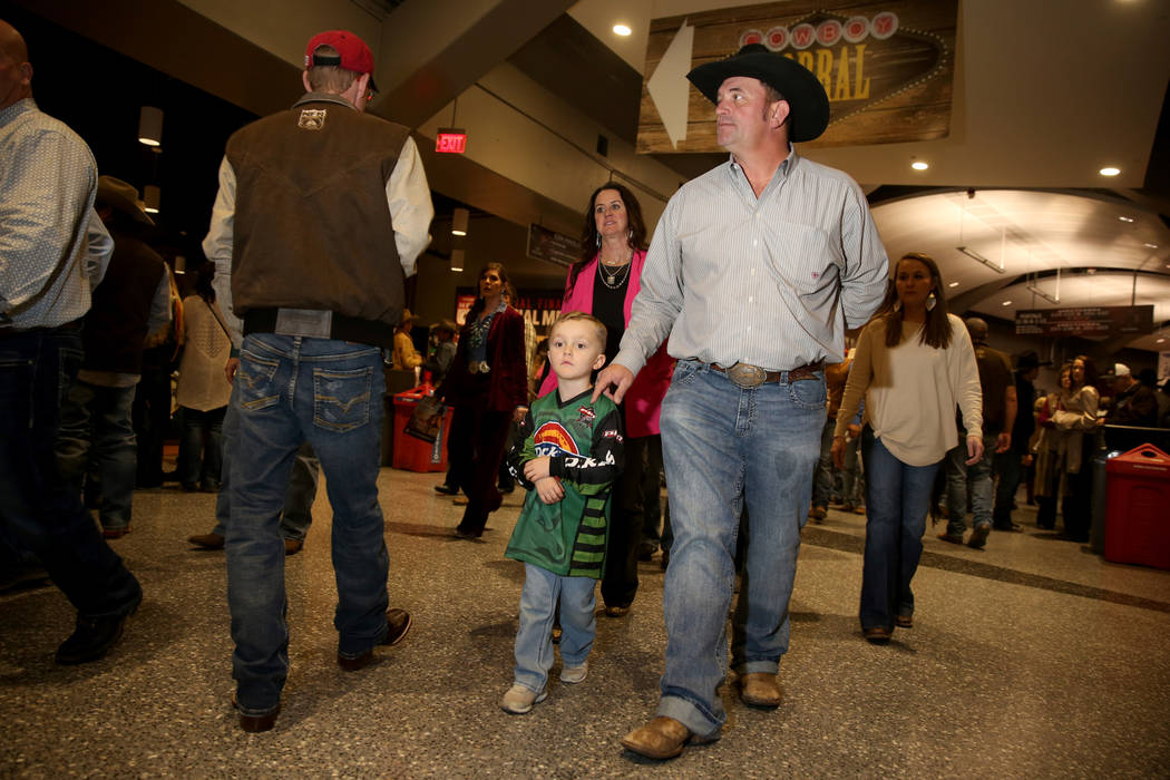 Missi Henderson, 43, of Winfield, Kan., walks to her seats with son Murphy, 4, and husband Shan ...