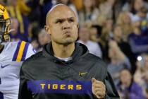 LSU defensive coordinator Dave Aranda runs on the field against Arkansas in an NCAA college foo ...