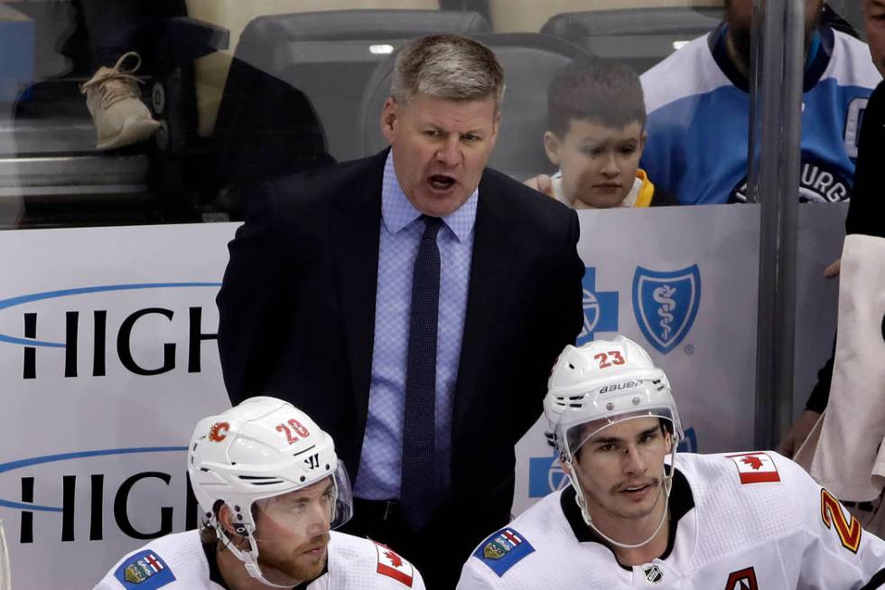 Calgary Flames head coach Bill Peters stands behind his bench during the third period of an NHL ...