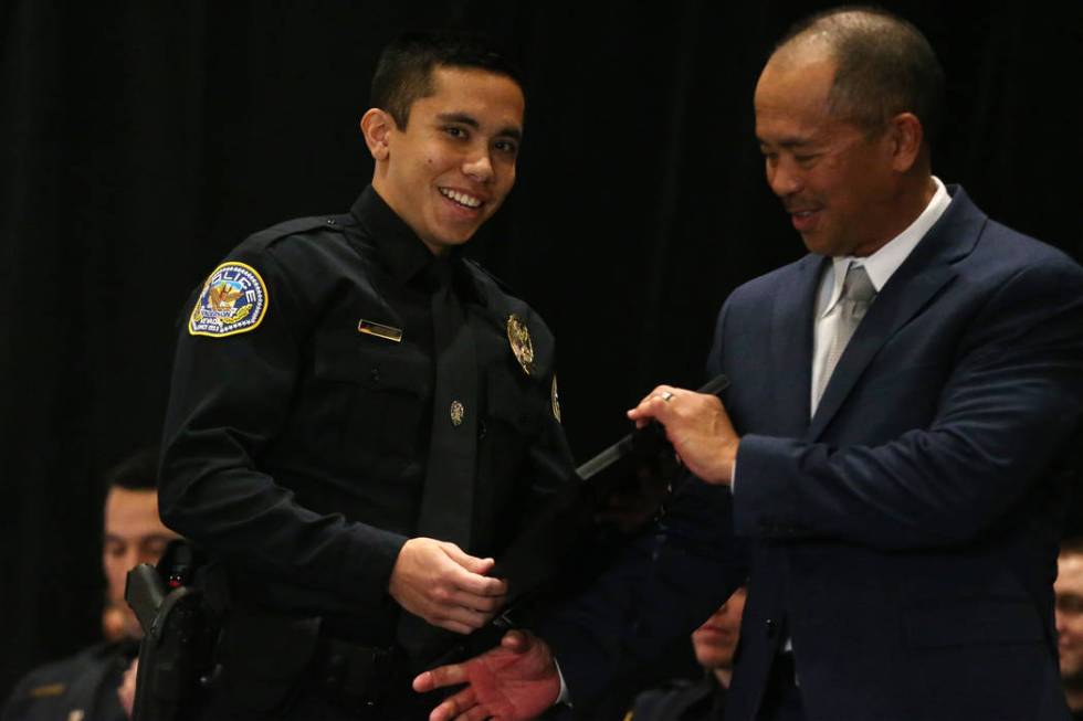 Joseph Fuentes smiles after getting pinned by his father Frank Fuentes, a retired officer from ...