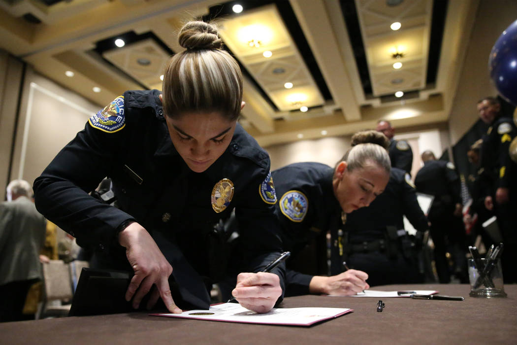 Samantha Nameth, left, and Genevieve Orris-Bowman, sign their oath of office in their graduatio ...