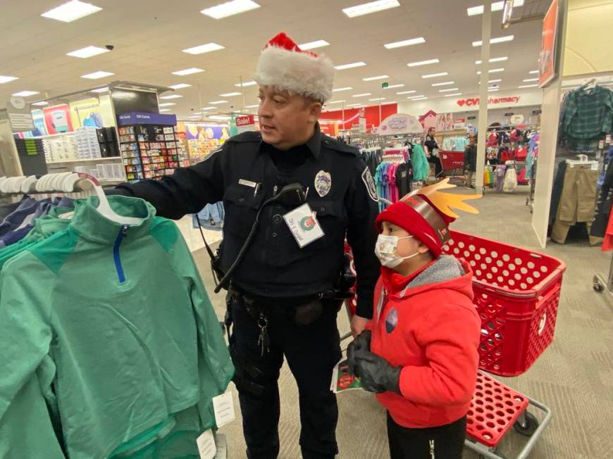 North Las Vegas patrol officer Edwin Corales shows Aiden Pinacruz some clothes he might want to ...