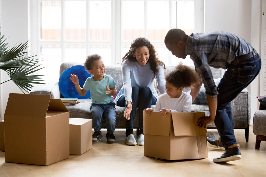 Happy playful large African American family moving in new apartment, little preschooler daughte ...