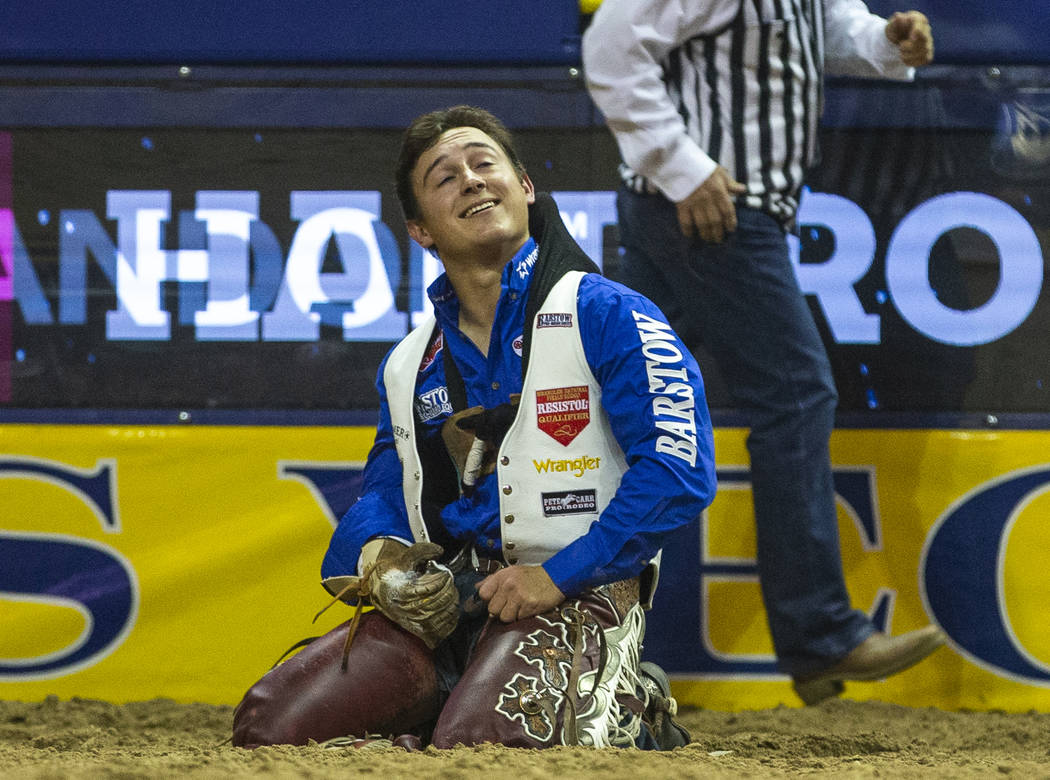 Clayton Biglow of Clements, Calif., looks up and smiles after he rides Ankle Biter to a first p ...