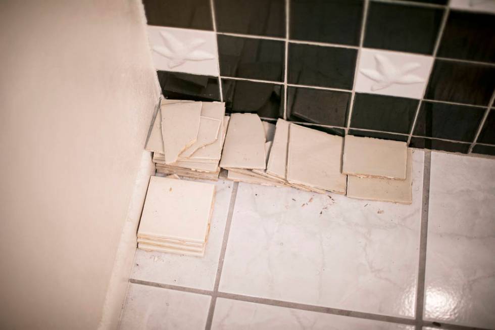 John and Mary Bodimer have gathered tiles that have fallen from the leaking ceiling in the gues ...