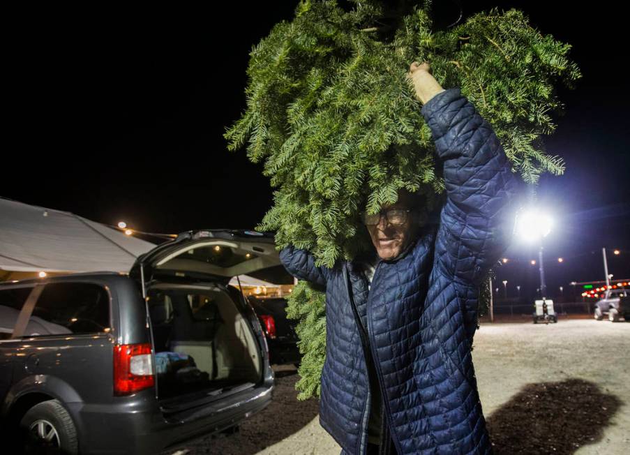 Jay Rogers carries a newly bought Christmas tree to a customers car on Wednesday, Dec. 11, 2019 ...