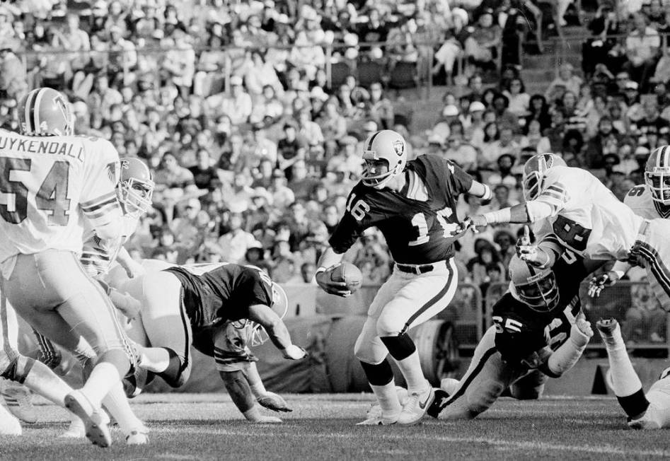 Oakland Raiders quarterback Jim Plunkett (16) gets his shirt pulled by Atlanta Falcons Joel Wil ...