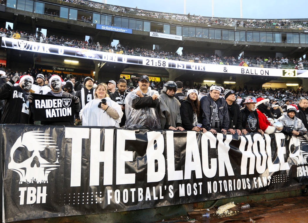 The fans in the Black Hole pose before the start of an NFL game between the Oakland Raiders and ...
