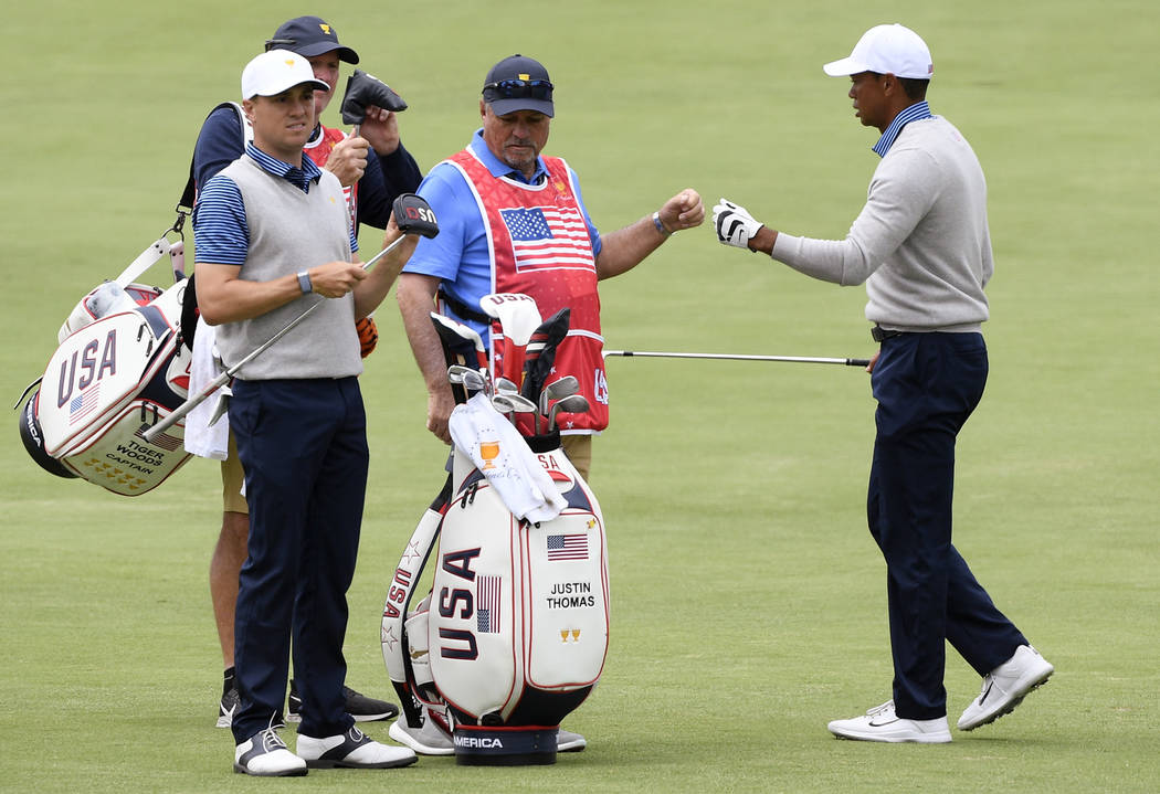 U.S. team player and captain Tiger Woods, right, and playing partner Justin Thomas, left, walk ...