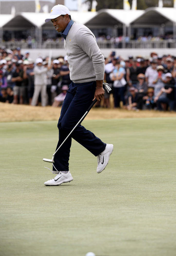 U.S. team player and captain Tiger Woods skips as he misses a putt on the 17th green in their f ...