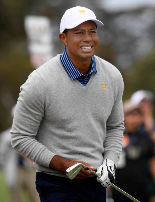 U.S. team player and captain Tiger Woods watches his shot on the 18th hole in their foursomes m ...