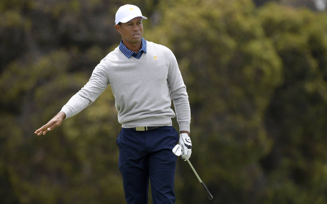 U.S. team player and captain Tiger Woods watches his shot on the 6th hole in their foursomes ma ...