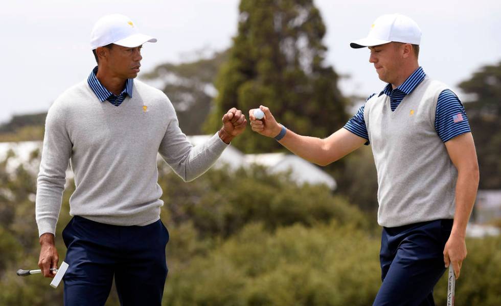 U.S. team player and captain Tiger Woods, left, and playing partner Justin Thomas fist bump aft ...