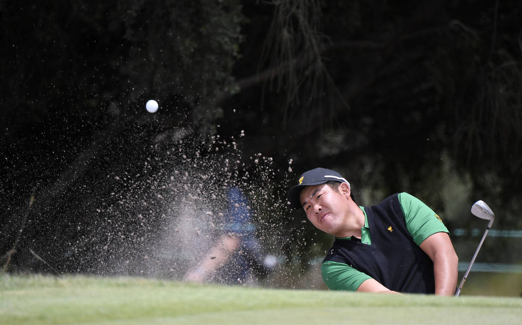 International team player Byeong Hun An of South Korea plays from a bunker at the 9th green in ...