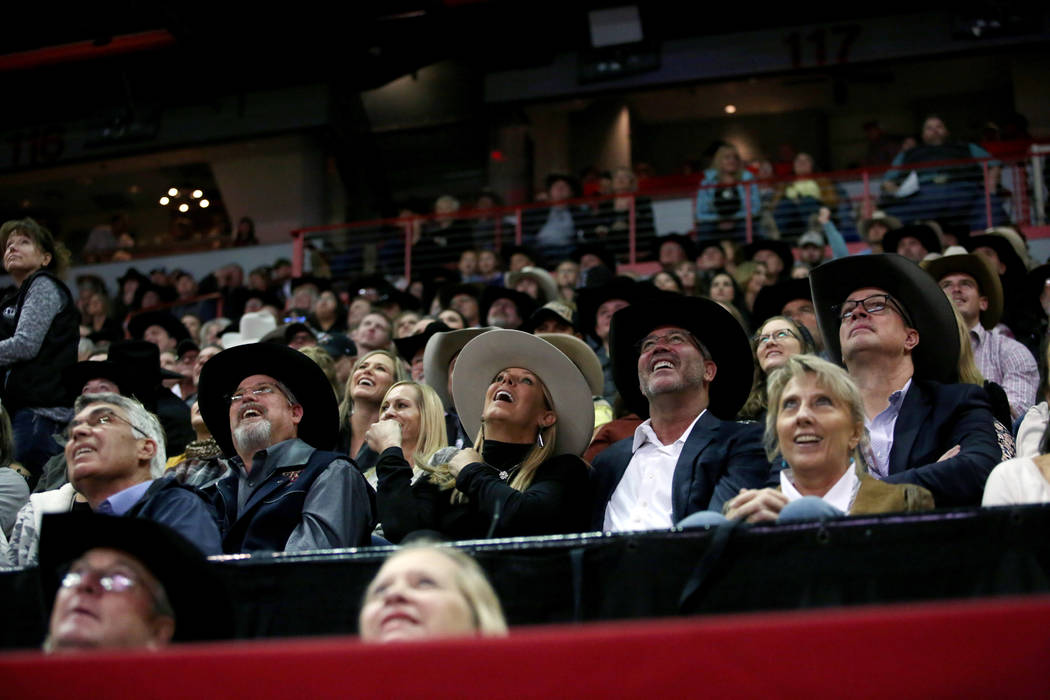 Attendees watch the replay of Team Roping during the eighth go-round of the Wrangler National F ...