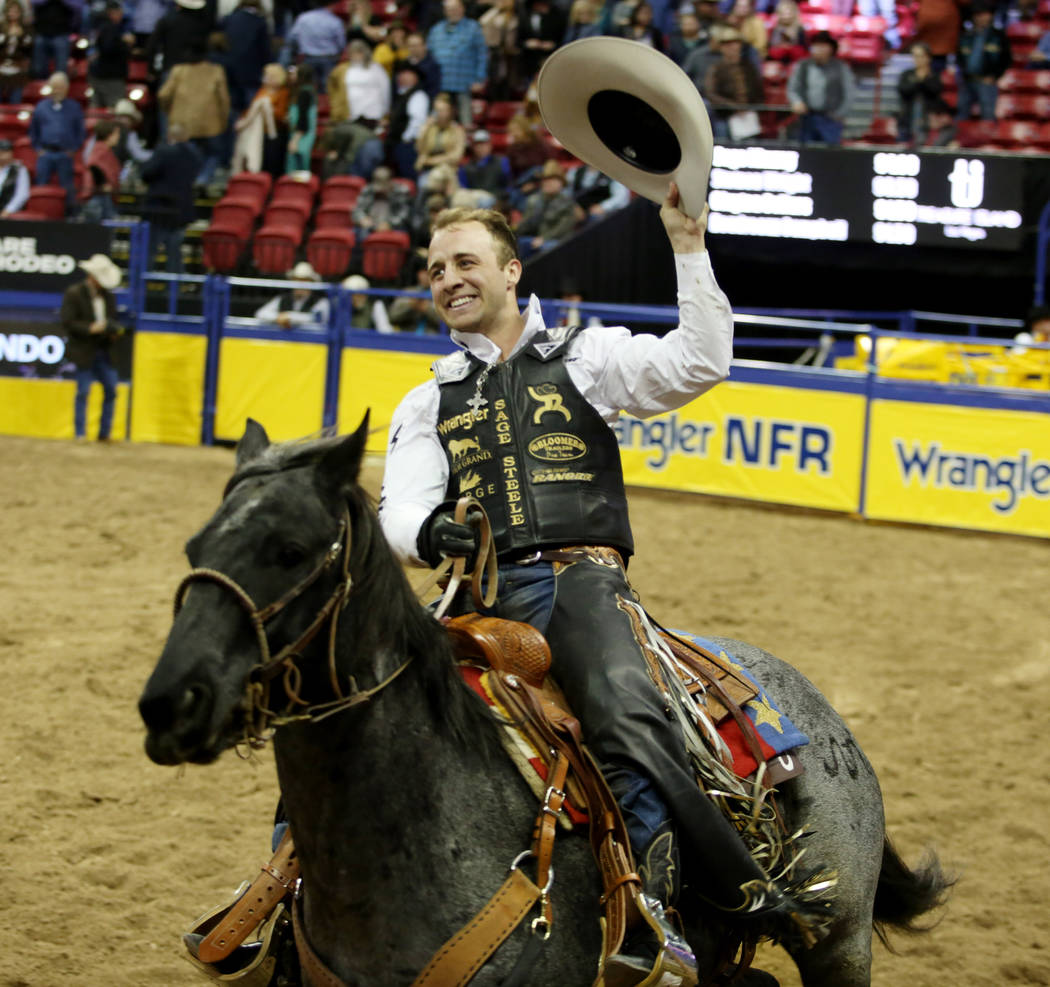 Sage Kimzey of Strong City, Okla. celebrates after placing first in Bull Riding in the eighth g ...