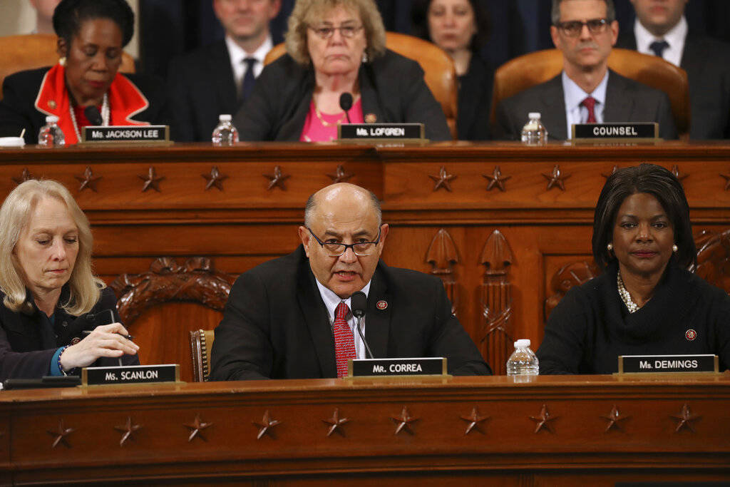 House Judiciary Committee member Rep. Luis Correa, D-Calif., center, votes for the first of two ...