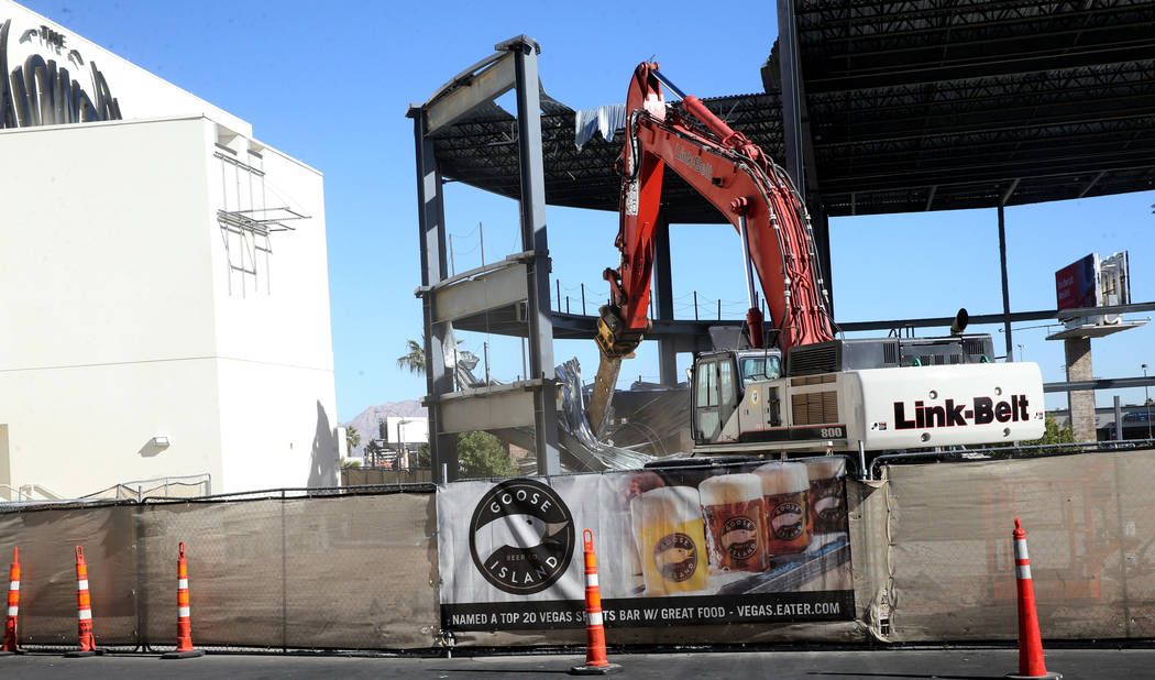 Crews from Las Vegas Demolition and Environmental Services demolish a structure behind the Hard ...