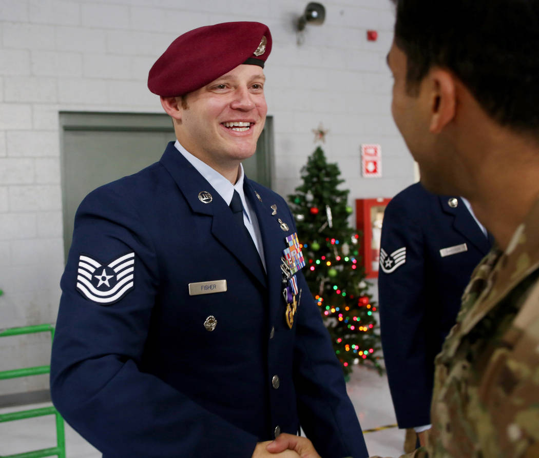 Technical Sgt. Gavin Fisher shakes the hand of a member of the military after a ceremony awardi ...