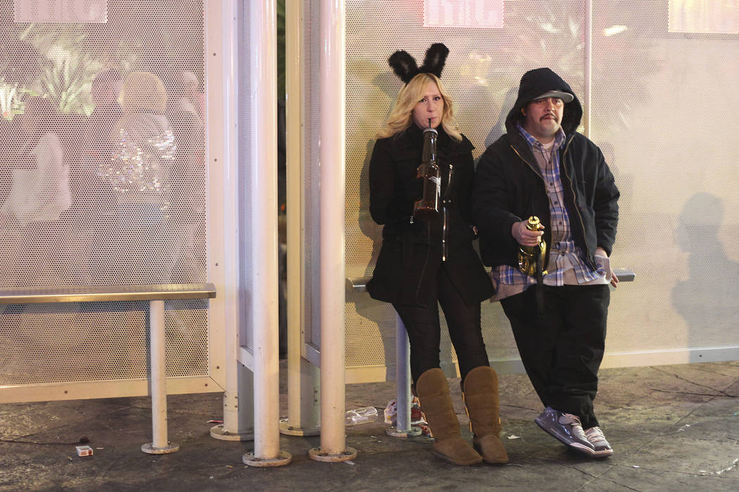 Two partyers take a break from the action during the New Year's Eve celebration on the Las Vega ...