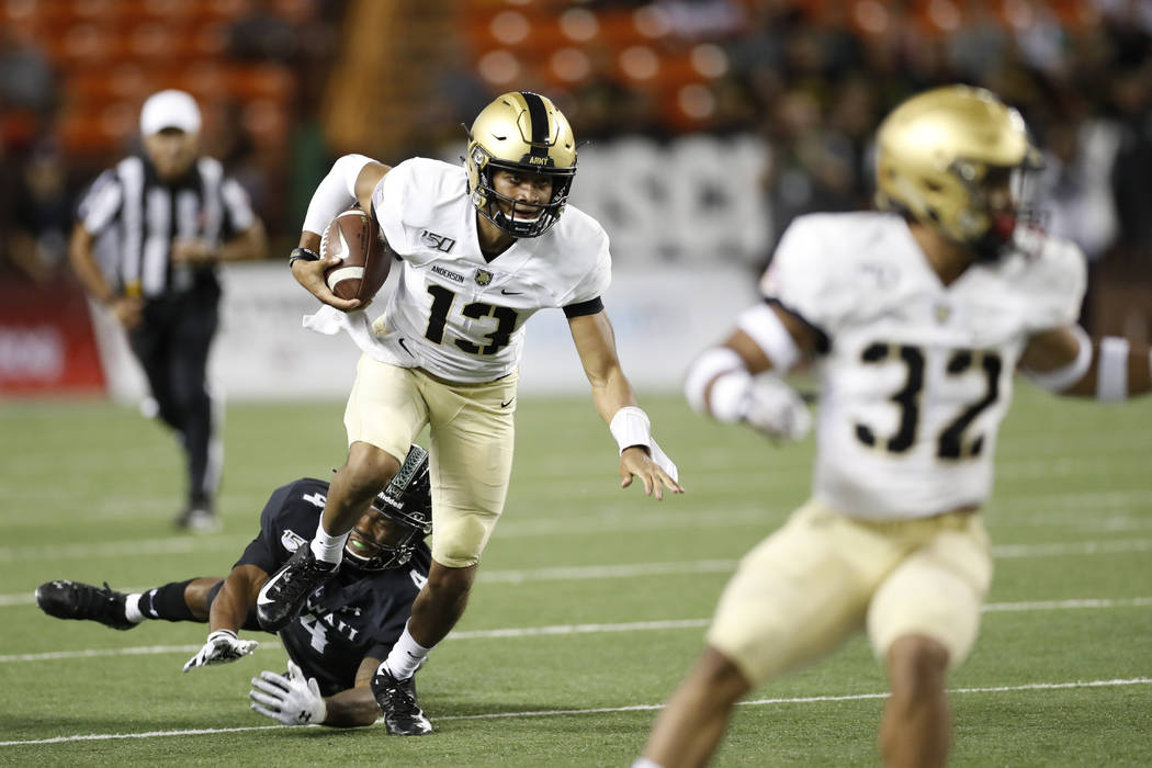 Army quarterback Christian Anderson (13) gets away from Hawaii defensive back Rojesterman Farri ...