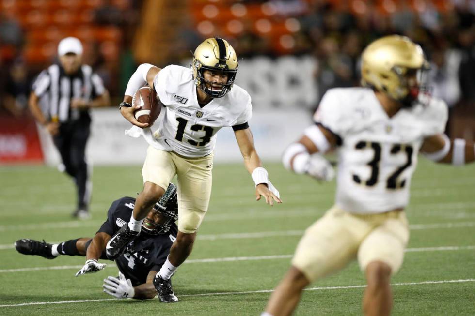 Army quarterback Christian Anderson (13) gets away from Hawaii defensive back Rojesterman Farri ...