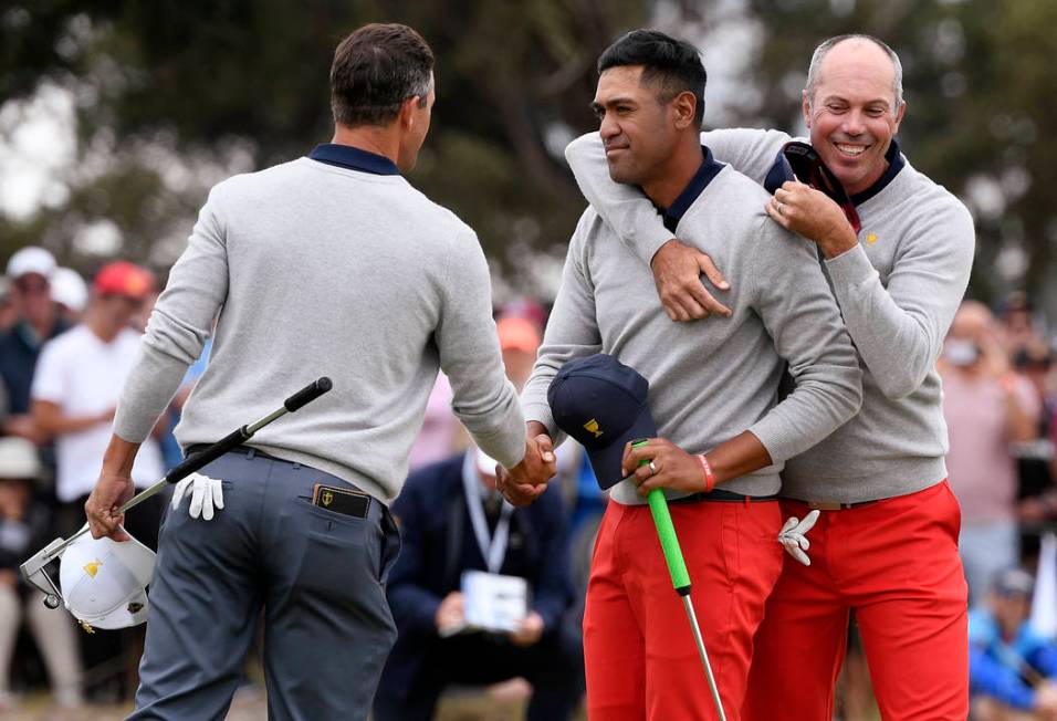 International team player Adam Scott of Australia, left, shakes hands with U.S. team player Ton ...