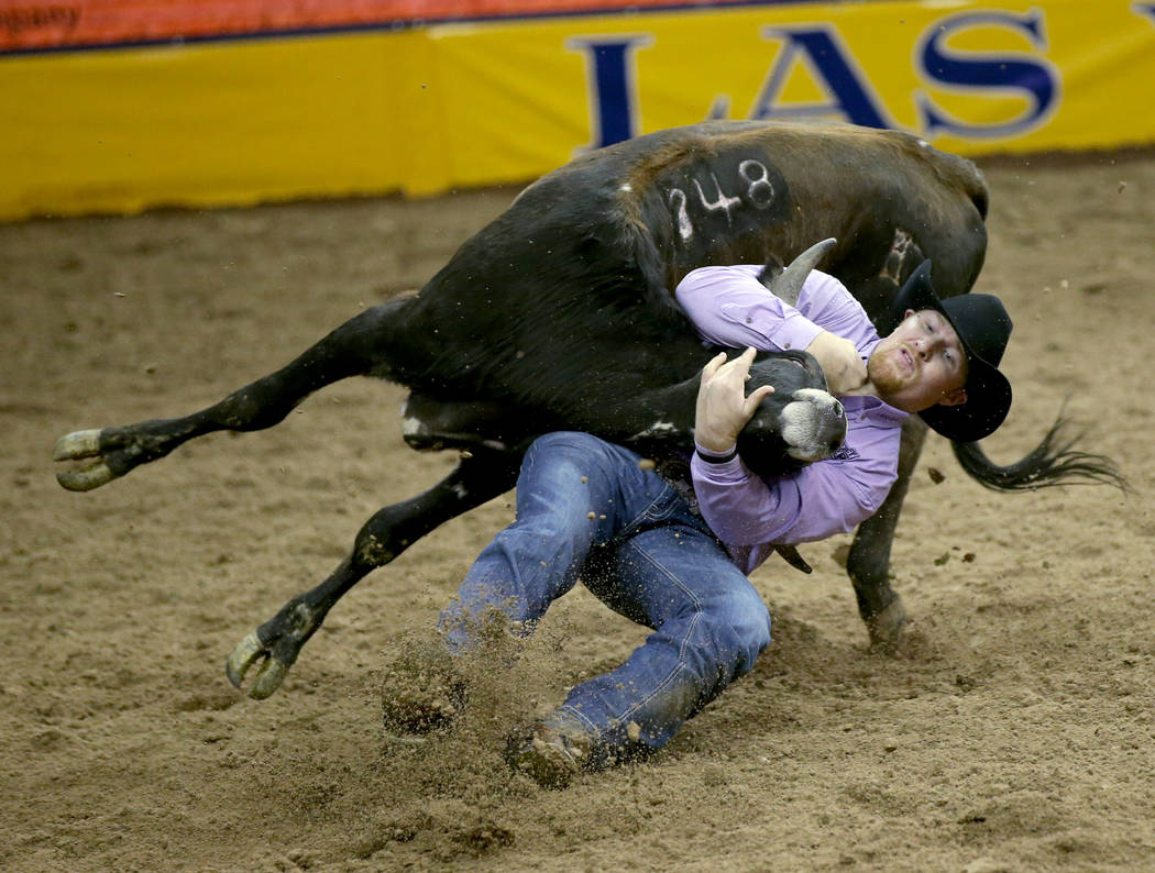 Stetson Jorgensen of Blackfoot, Idaho competes in Steer Wrestling during the ninth go-around of ...