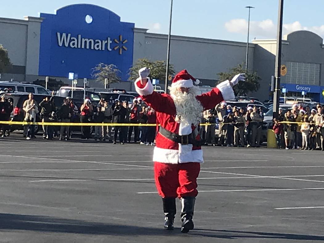 Santa Claus waves to children during a "Santa Cops" event on Saturday, Dec. 14, 2019, at Walmar ...