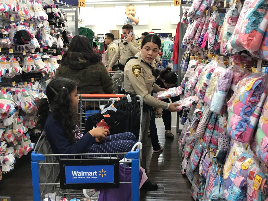 Metropolitan Police Department officer Alexis Hodler shops with 6-year-old Cathalina Correa dur ...