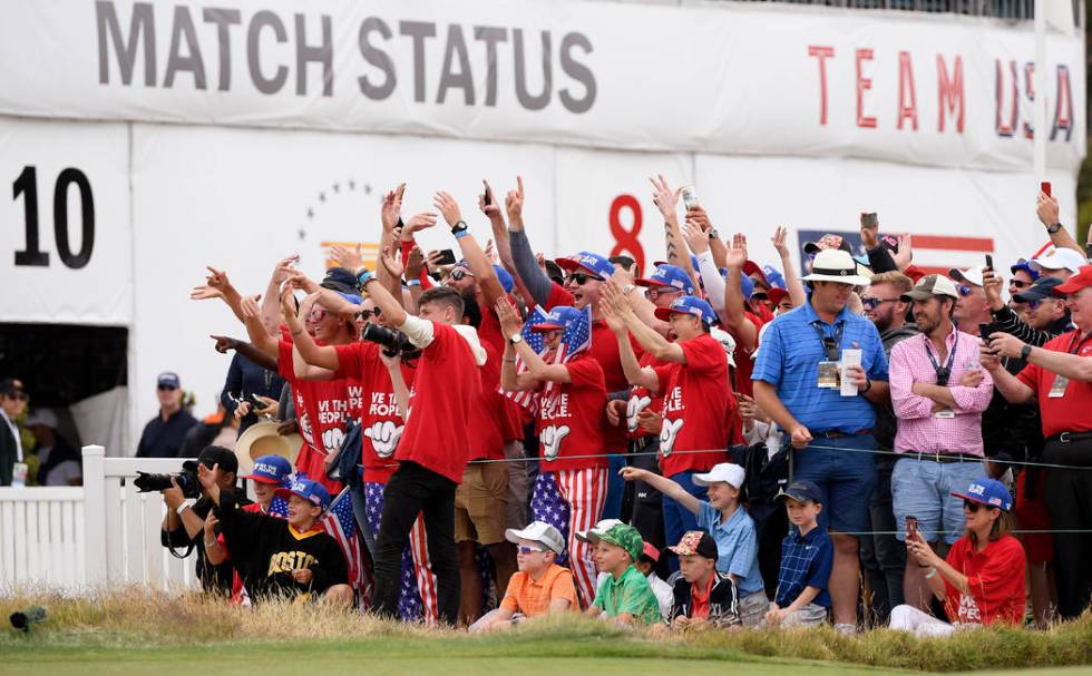 Fans of the U.S. team celebrate at the 16th hole after U.S. team player and captain Tiger Woods ...