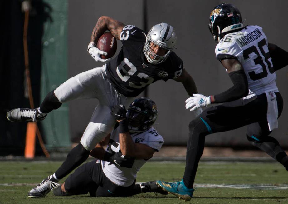 Oakland Raiders tight end Darren Waller (83) fights for extra yardage with Jacksonville Jaguars ...