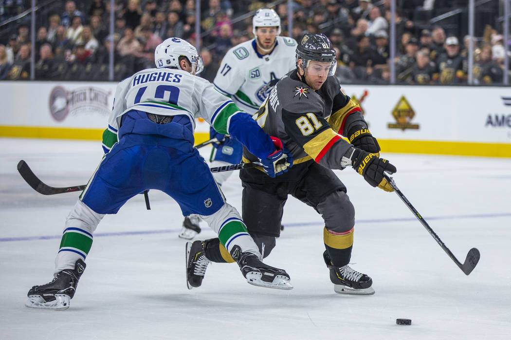 Vegas Golden Knights center Jonathan Marchessault (81) squeezes past Vancouver Canucks defensem ...