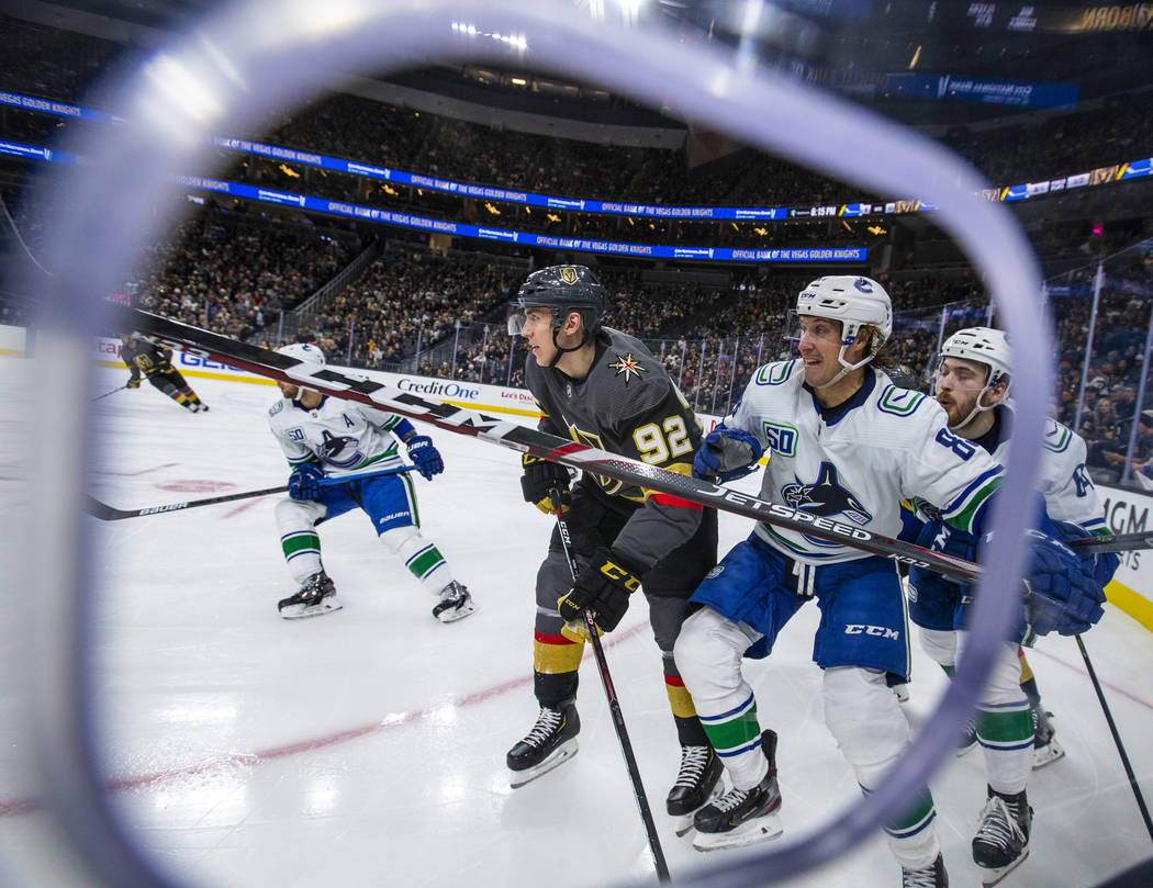 Vegas Golden Knights left wing Tomas Nosek (92, center) battles for position with Vancouver Can ...