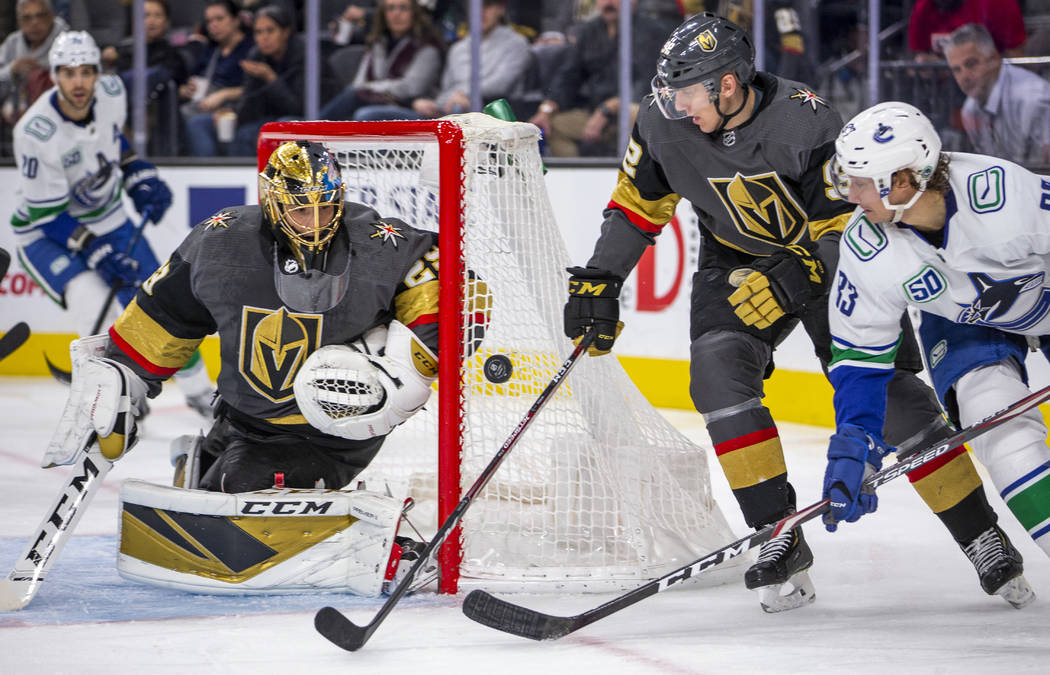 Vegas Golden Knights goaltender Marc-Andre Fleury (29, left) looks to a shot past teammate left ...